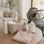 Summer essentials for new moms including a water bottle, diaper caddy, stroller fan, bottle warmer, and nursing top
